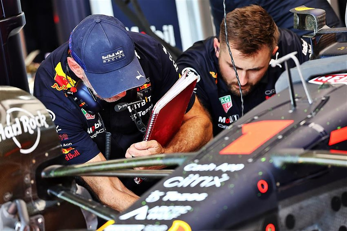 image of Christian Horner over a F1 car with a paper notebook, perhaps applying tape to the car. Source: https://formula1news.co.uk/you-cant-beat-a-bit-of-gaffer-tape-christian-horner-on-max-verstappen-repairs/