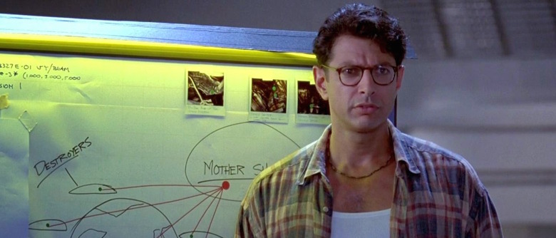 Jeff Goldblum in Independence Day in front of a board that shows "mother ship" behind it.