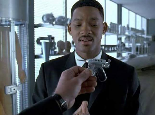 Still from Men in Black, Will Smith's character is looking skeptical at being handed a tiny gun.